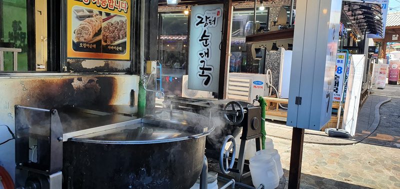 가게 입구에서 김이 오르는 육수 솥